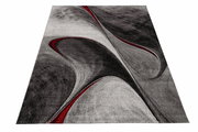 Moderner Teppich in Grautönen mit roten Akzenten, abstraktes Design, Perspektive von schräg oben.