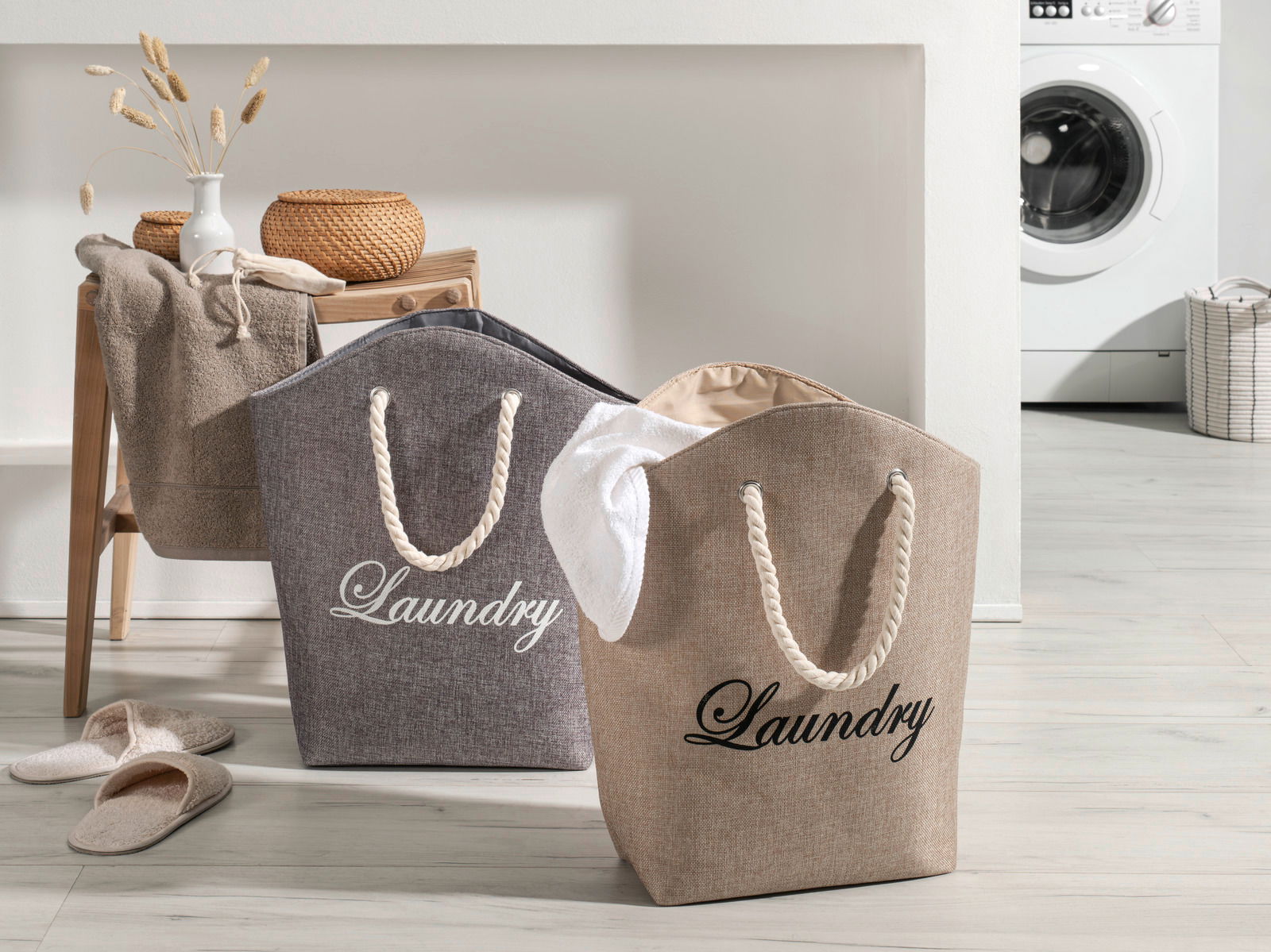 Zurbrüggen Wäschesack SUMMERGIFT Zwei Wäschesäcke mit der Aufschrift 'Laundry' in einem modernen Waschraum, einer in Grau und einer in Beige, mit Seilgriffen, aus der Vorderansicht fotografiert.