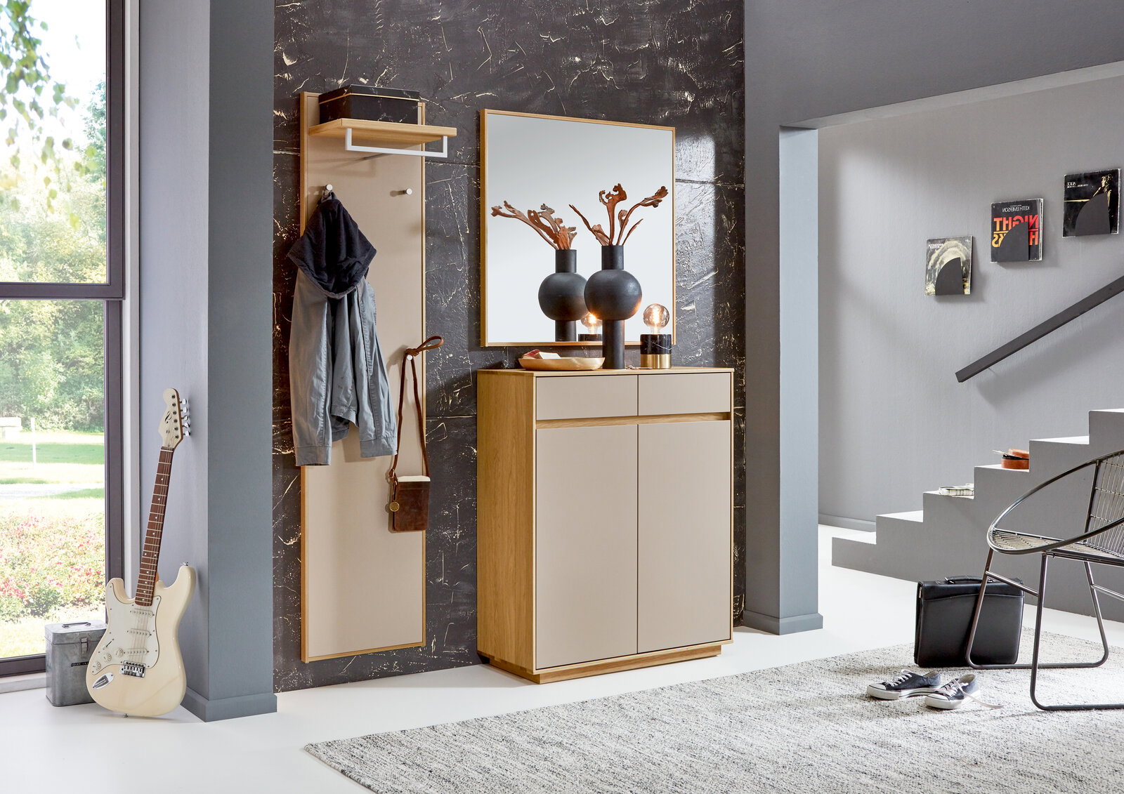 Moderner Eingangsbereich mit Garderobenpaneel, Spiegel und Kommode in Holzoptik, seitliche Perspektive.