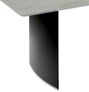 Detailansicht eines Esstisches mit schwarzem, gebogenem Tischbein und heller Tischplatte.