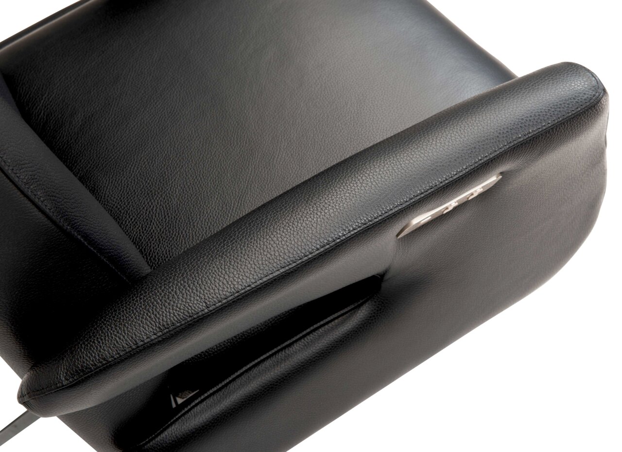 Nahaufnahme eines schwarzen Relaxsessels aus Leder, Ansicht von oben mit sichtbarer Armlehne und Bedienelement.