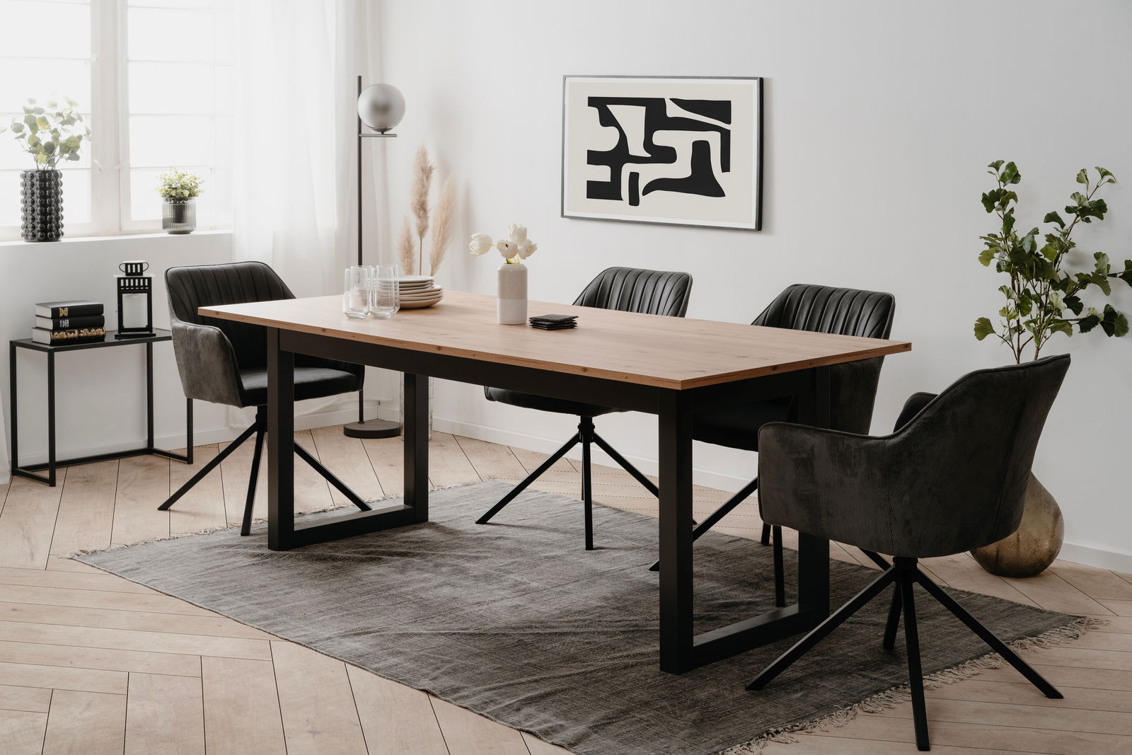 Z2 Esstisch Denver Moderner Esstisch mit Holzplatte und schwarzen Metallbeinen, umgeben von vier schwarzen Stühlen in einem hellen, stilvollen Esszimmer. Perspektive von der Seite.