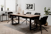 Moderner Esstisch mit Holzplatte und schwarzen Metallbeinen, umgeben von vier schwarzen Stühlen in einem hellen, stilvollen Esszimmer. Perspektive von der Seite.