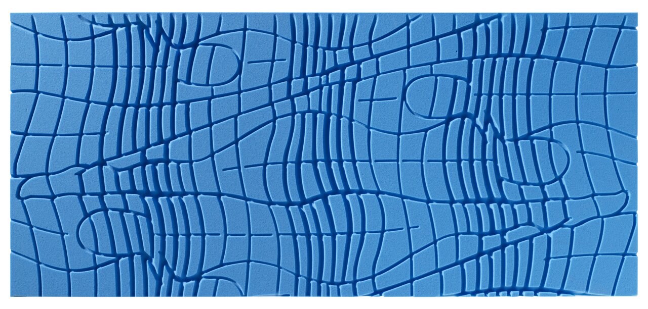Nahaufnahme einer blauen Gel-Kaltschaummatratze mit einem komplexen, wellenförmigen Muster auf der Oberfläche, von oben betrachtet.
