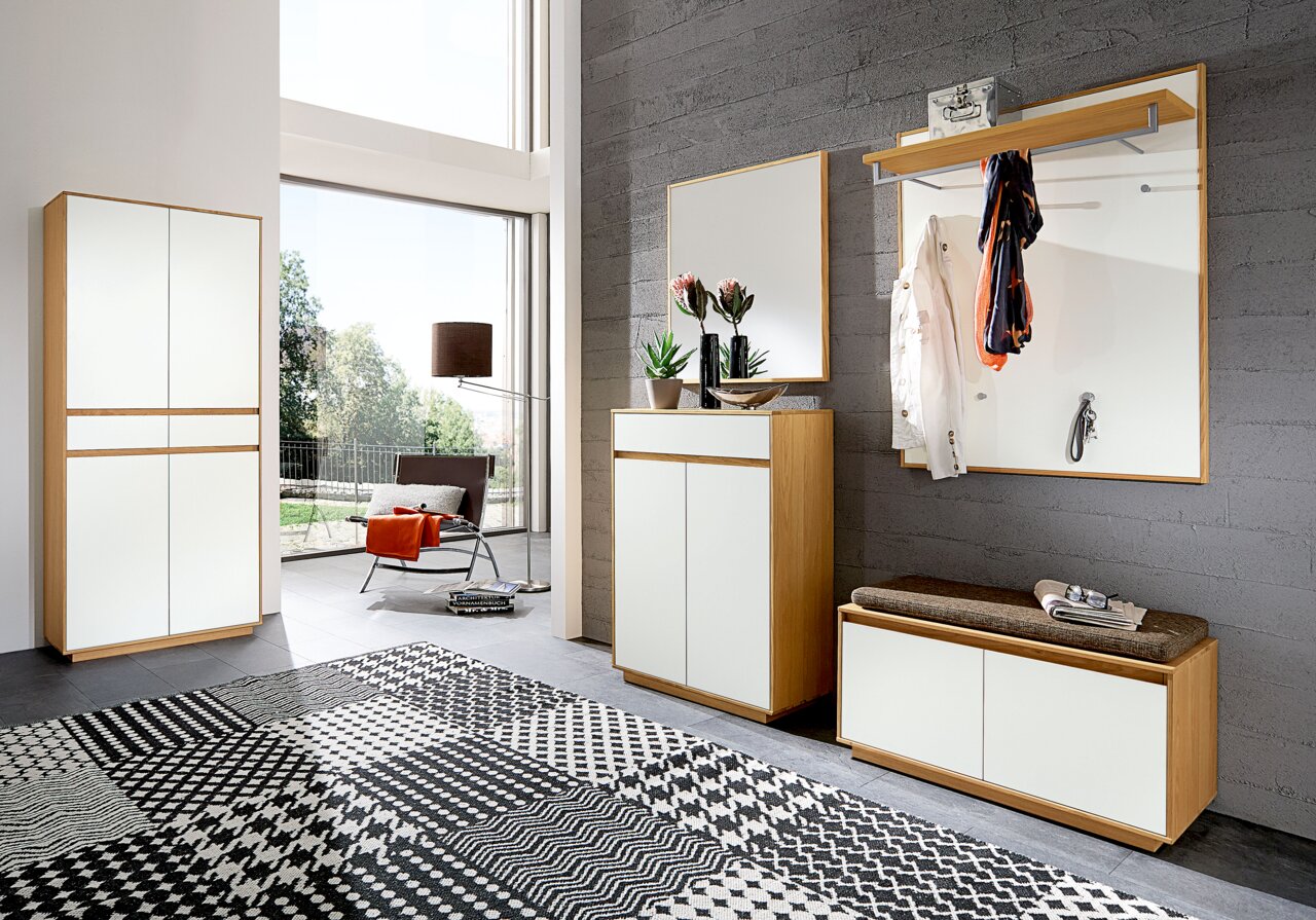 Moderne Garderobeneinrichtung mit Holz- und Weißakzenten, bestehend aus einem Schuhschrank, einer Kommode, einem Spiegel und einer Garderobenbank. Perspektive von vorne.