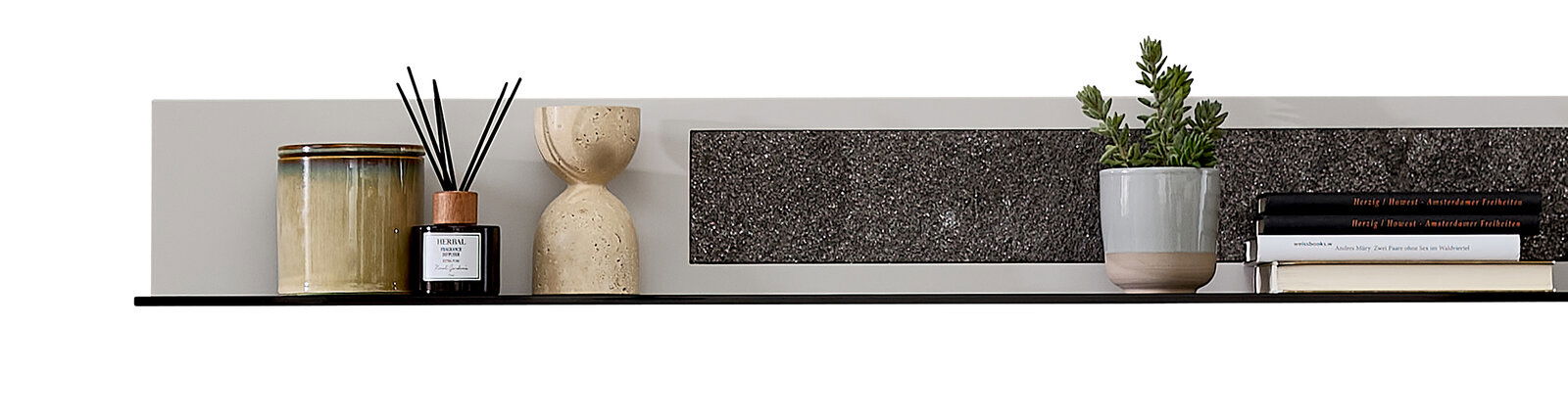 Modernes Wandboard mit Dekorationen, darunter ein Keramikgefäß, ein Diffuser, eine Sanduhr, ein Pflanzentopf und Bücher, aus seitlicher Perspektive.