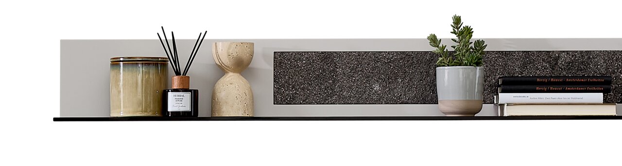 Modernes Wandboard mit Dekorationen, darunter ein Keramikgefäß, ein Diffuser, eine Sanduhr, ein Pflanzentopf und Bücher, aus seitlicher Perspektive.