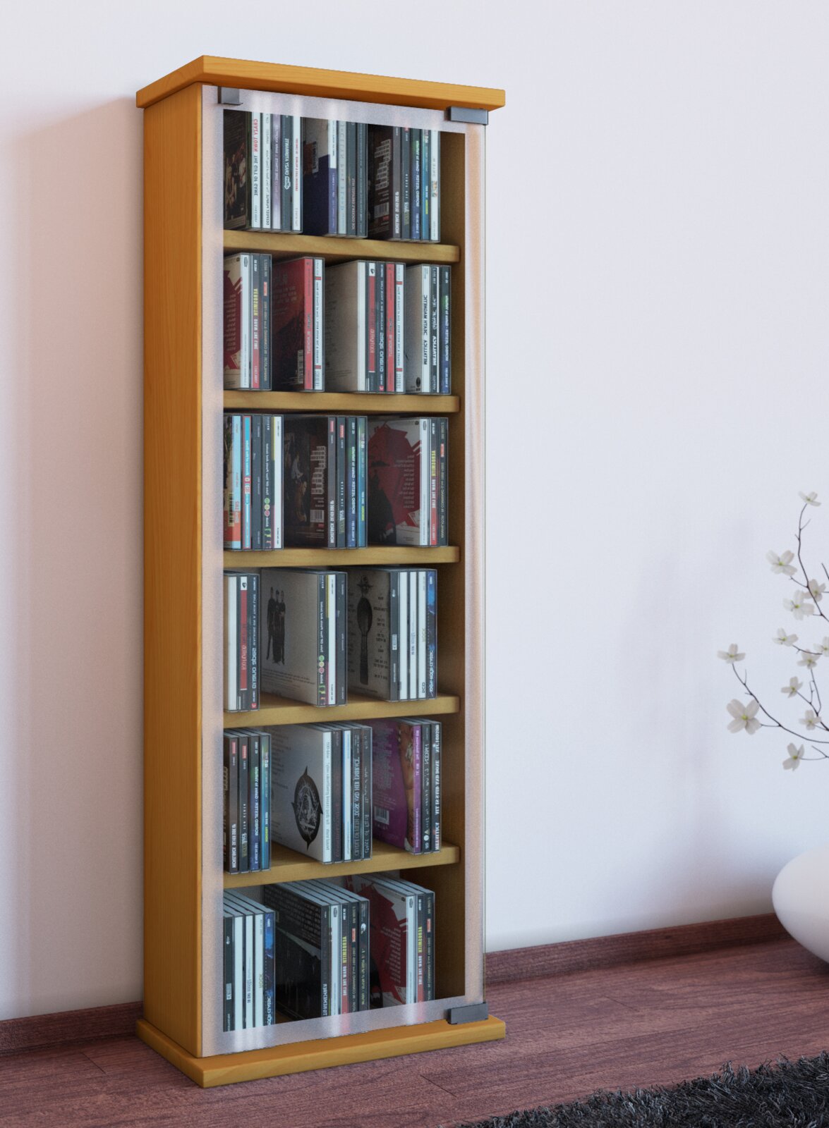 Schmaler CD-/DVD-Turm aus hellem Holz mit Glastür und mehreren Regalböden, gefüllt mit CDs, in leichter Schrägansicht von vorn links vor einer weißen Wand.