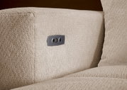 Nahaufnahme der seitlichen Armlehne eines beigen Bouclé-Sofas mit integrierter USB-Ladebuchse in Metallblende, perspektivisch leicht von vorne und seitlich aufgenommen
