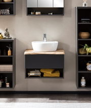 Modernes Waschtisch-Set mit weißem Waschbecken auf Holzplatte, umgeben von schwarzen Regalen, Frontalansicht.