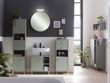Moderner Waschbeckenunterschrank in einem stilvollen Badezimmer, frontal betrachtet, mit grünen Schranktüren und Holzbeinen, umgeben von weiteren passenden Möbeln und Dekorationen.