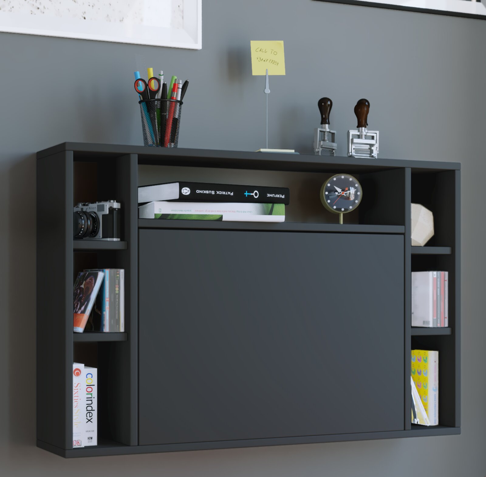 Anthrazitfarbenes Sideboard mit Klapptür und offenen Regalfächern, dekoriert mit Büchern, Stiftebecher, Kamera und kleiner Uhr, aufgenommen in frontaler Perspektive auf Augenhöhe.