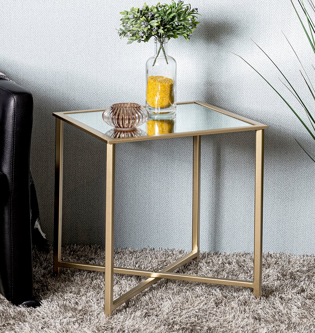 Quadratischer Beistelltisch mit goldfarbenem Metallgestell und Glasplatte, seitliche Perspektive im Wohnzimmer neben Sofa, dekoriert mit Vase und Schale