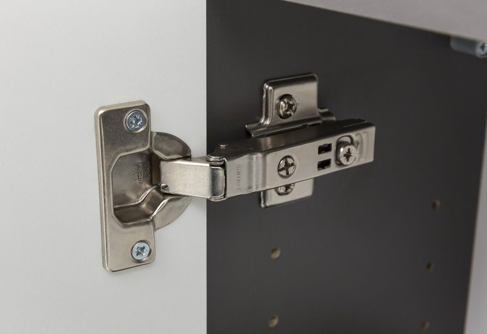 Nahaufnahme eines Metallscharniers an einem Midischrank, seitliche Perspektive