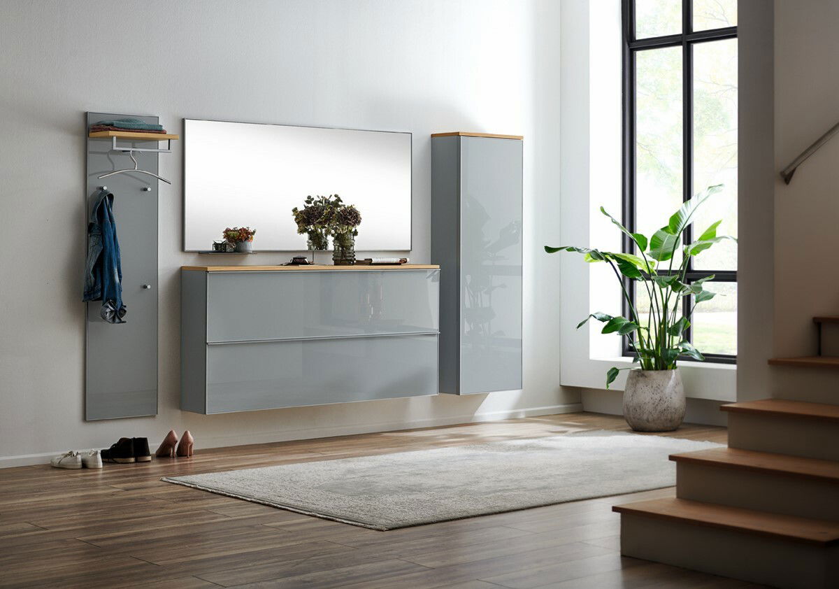 Moderne Hängegarderobe in einem hellen Raum, mit einem großen Spiegel und Pflanzen, aus der Perspektive des Eingangsbereichs betrachtet.