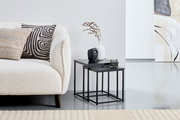 Beistelltisch-Set in modernem Design, bestehend aus zwei schwarzen Tischen mit Metallgestell, dekoriert mit Vasen und Kerze, seitliche Perspektive.