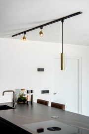 Moderne Pendelleuchte FLORIS in mattgoldener Ausführung, von der Decke hängend über einer Kücheninsel, seitliche Perspektive.