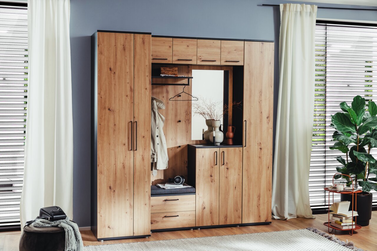 Garderobenkombination aus Holz mit Schränken, Spiegel und Sitzbank, frontal fotografiert in einem modern eingerichteten Raum.