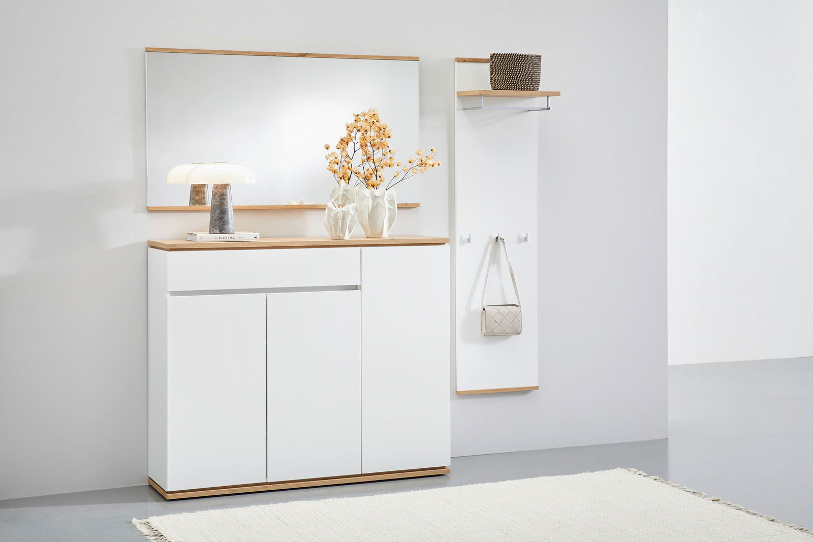 Moderne Garderobenkombination mit weißem Sideboard, großem Spiegel und Garderobenpaneel, seitliche Perspektive