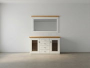 Frontansicht eines weißen Sideboards mit Holzplatte, zwei Glastüren und vier Schubladen, darüber ein passender Wandspiegel mit Holzabschluss vor heller Wand