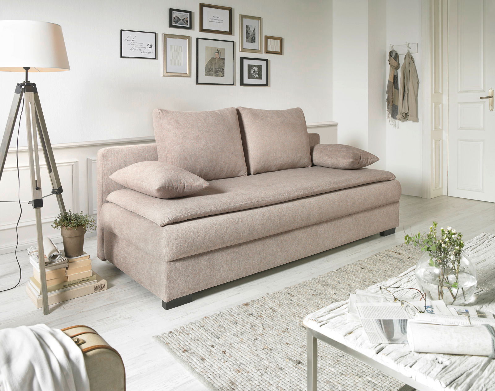 Z2 Schlafsofa SANTO Beiges Funktionssofa in einem hellen Wohnzimmer, seitliche Perspektive, mit Kissen und dekorativen Elementen.