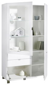 Weiße Vitrine mit Glastüren, Regalen und Schubladen, gefüllt mit Geschirr und Dekorationen, aus einer leicht seitlichen Perspektive.