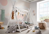 Tipibett aus weißem Holz mit dekorativen Lichterketten und Wimpeln, umgeben von Kuscheltieren und Spielzeug in einem hellen Kinderzimmer mit großem Fenster.
