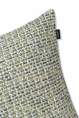 Nahaufnahme einer Zierkissenhülle mit grobem, mehrfarbigem Webmuster in Grün-, Blau- und Beigetönen, seitliche Perspektive.