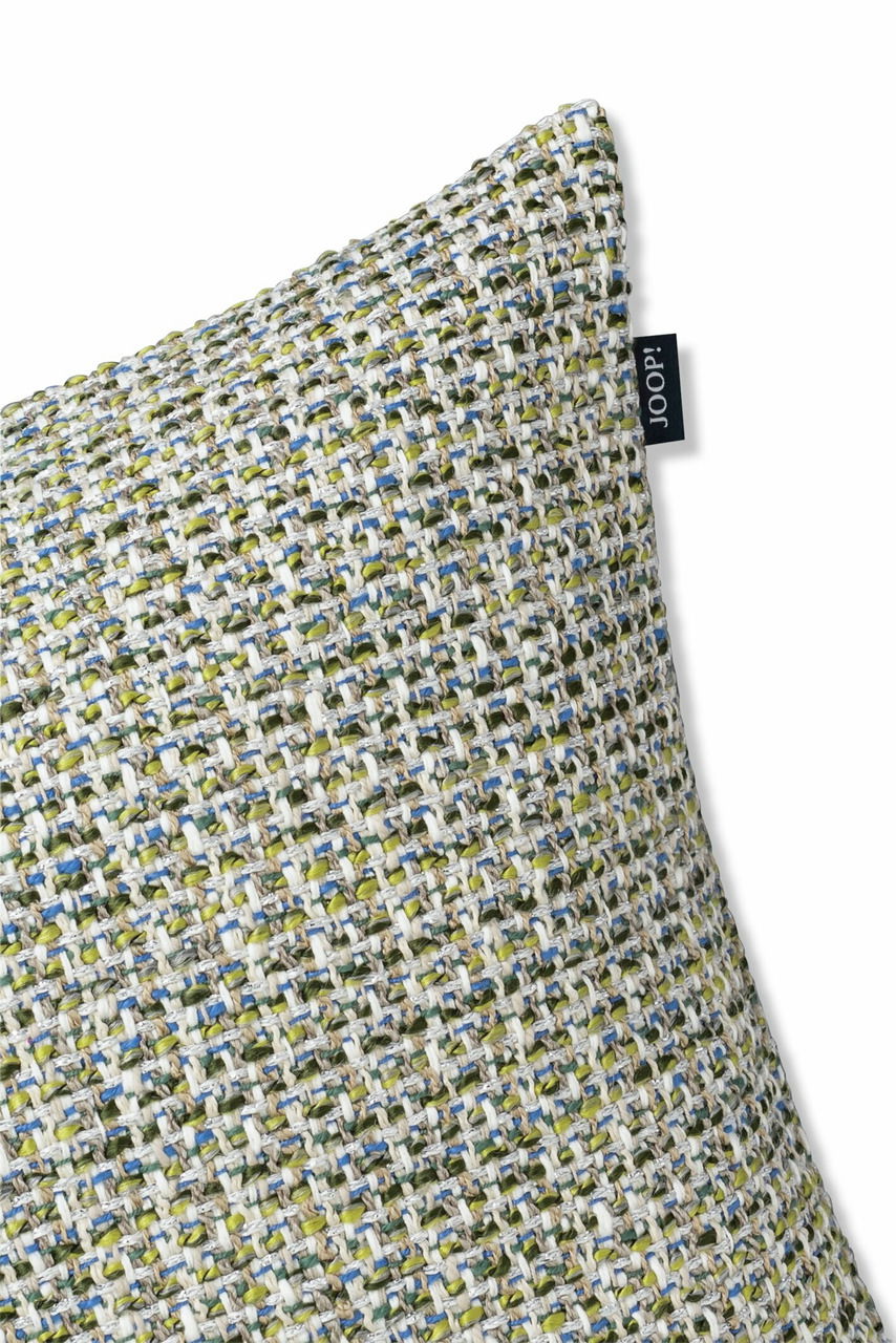 Nahaufnahme einer Zierkissenhülle mit grobem, mehrfarbigem Webmuster in Grün-, Blau- und Beigetönen, seitliche Perspektive.