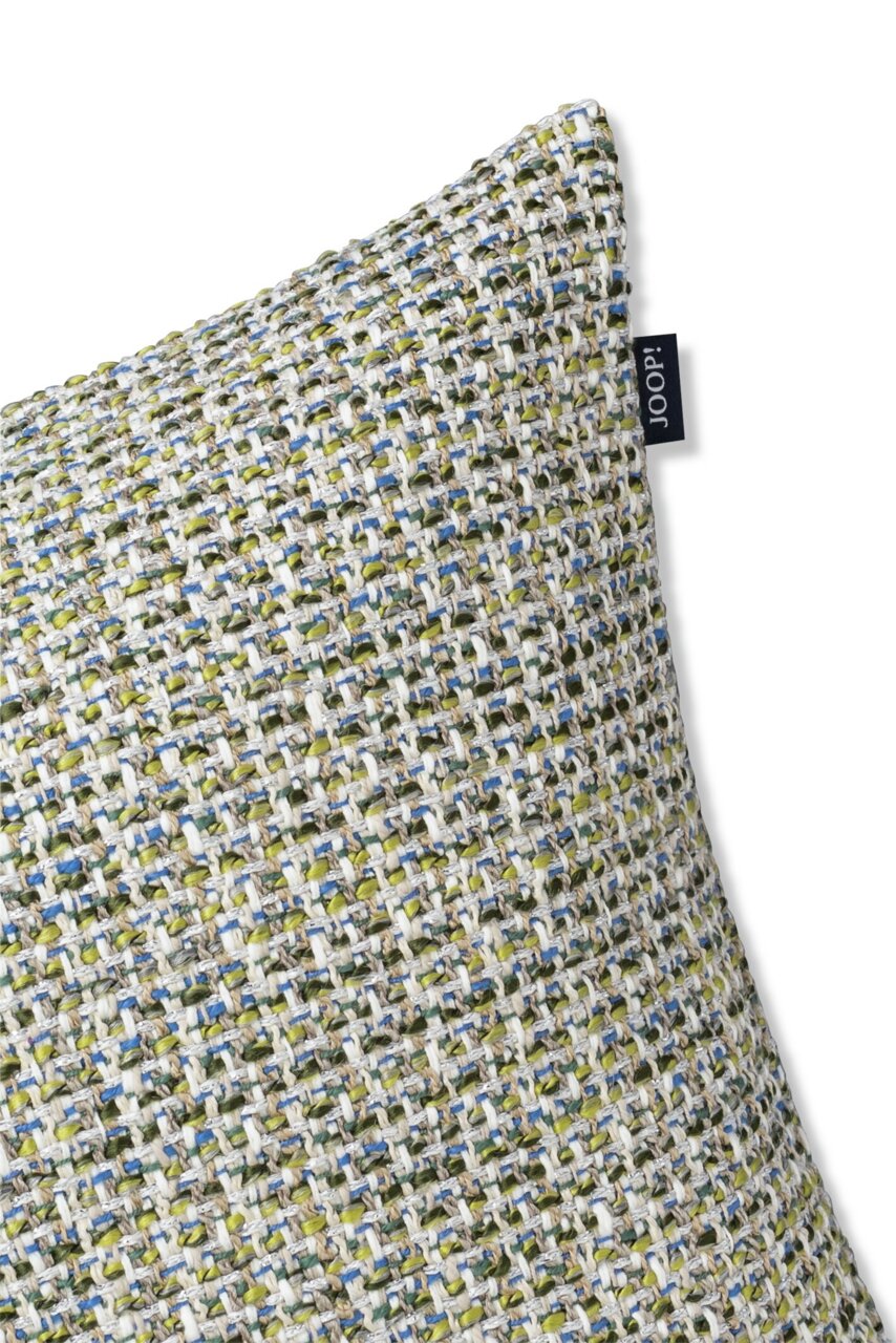 Nahaufnahme einer Zierkissenhülle mit grobem, mehrfarbigem Webmuster in Grün-, Blau- und Beigetönen, seitliche Perspektive.