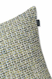 Nahaufnahme einer Zierkissenhülle mit grobem, mehrfarbigem Webmuster in Grün-, Blau- und Beigetönen, seitliche Perspektive.