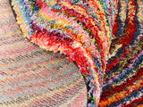Nahaufnahme eines bunten Hochflor-Teppichs mit lebendigen Farben aus der Seitenperspektive.