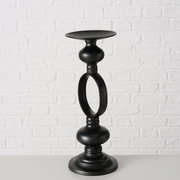 Schwarzer Kerzenleuchter Plokky aus Metall, frontal vor einer weißen Ziegelwand fotografiert.