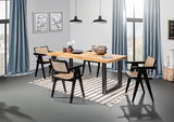 Moderner Esstisch aus Holz mit schwarzen Metallbeinen, umgeben von vier Stühlen mit geflochtenen Sitzflächen, in einem stilvoll eingerichteten Raum mit großen Fenstern und blauen Vorhängen, aus seitlicher Perspektive.
