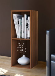 Schmales, zweifächriges Holzregal in warmem Braun neben einem Sofa, oben mit Büchern und unten mit weißer Vase und Zweigen dekoriert, aus frontaler leicht seitlicher Perspektive.