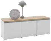 Modernes Sideboard in Weiß mit Holzplatte, darauf eine graue Tischlampe und eine runde Glasvase, Ansicht schräg von vorne (3/4-Perspektive)