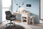 Moderner Schreibtisch in heller Holzoptik mit Schublade und Regal, seitliche Perspektive, dekoriert mit Lampe, Vasen und Büchern, neben einem großen Fenster mit Blick auf verschneite Landschaft.