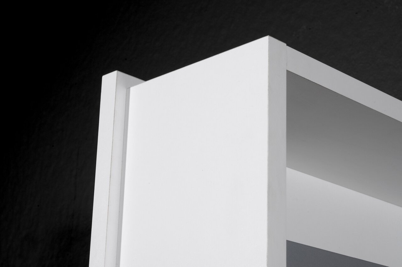 Nahaufnahme eines weißen Drehschuhschranks von oben, zeigt die klare Linienführung und das minimalistische Design.