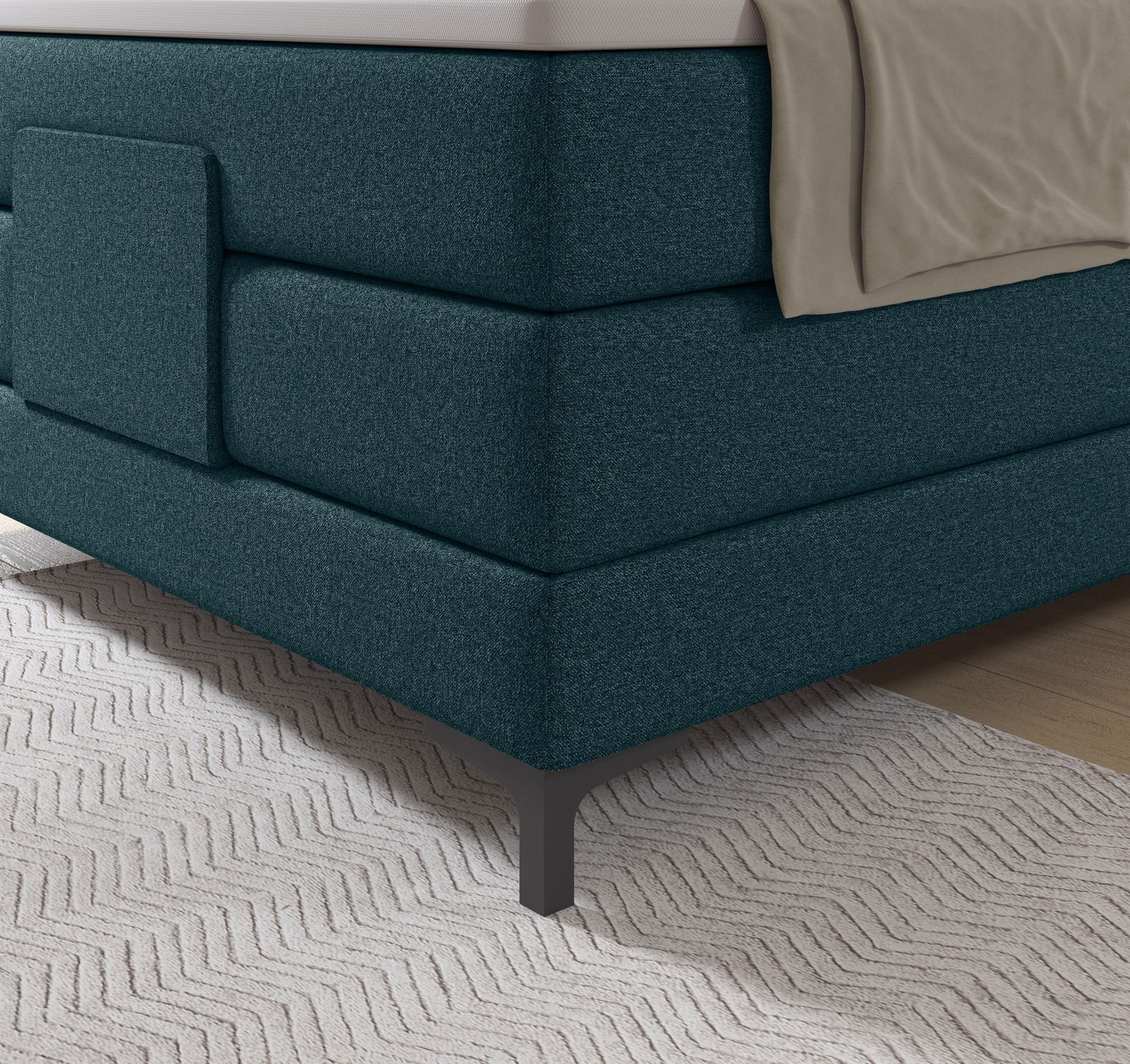 Ecke eines Boxspringbetts in dunkelgrünem Stoffbezug mit Metallfüßen, seitliche Perspektive