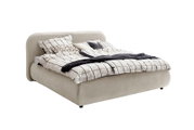Het gestoffeerde bed LISSABON in zijaanzicht, met een beige stoffen bekleding en beddengoed met patroon.