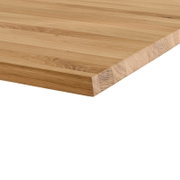 Massive Holzplatte mit sichtbarer Maserung und Lamellenverleimung, Nahaufnahme in schräger Draufsicht auf die Ecke