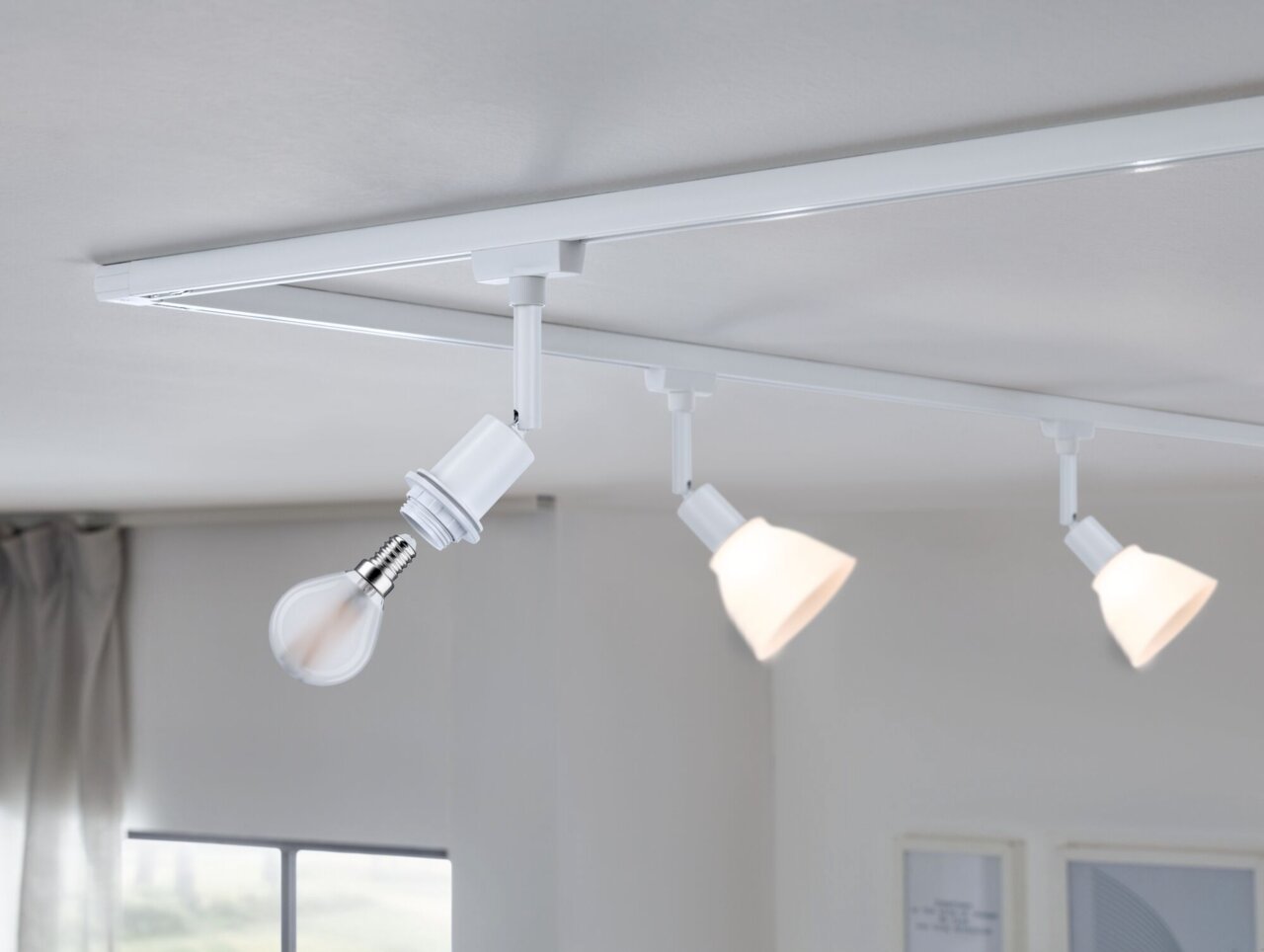 PAULMANN Basisspot URAIL Deckenmontiertes URail Basisspot-System von Paulmann mit drei weißen Spots, seitliche Perspektive.