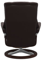 Achteraanzicht van een donkerbruine, gevoerde relaxfauteuil met hoge rugleuning, armleuningen en ronde draaivoet in houtlook met zilverkleurige steunen.