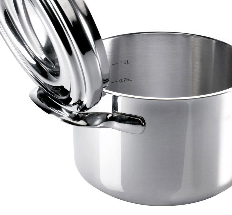 Nahaufnahme eines glänzenden Edelstahltopfs mit geöffnetem Deckel, sichtbare Messskala im Inneren.