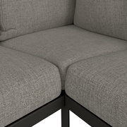 Nahaufnahme einer grauen Loungeecke mit Textilbezug und Metallrahmen, Perspektive von oben.