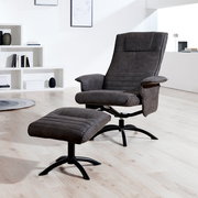 Moderner Relaxsessel mit Hocker in dunklem Stoffbezug, seitliche Perspektive in einem hellen Raum.