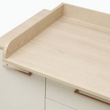 Wickelaufsatz aus hellem Holz, von oben betrachtet, auf einer Kommode montiert.