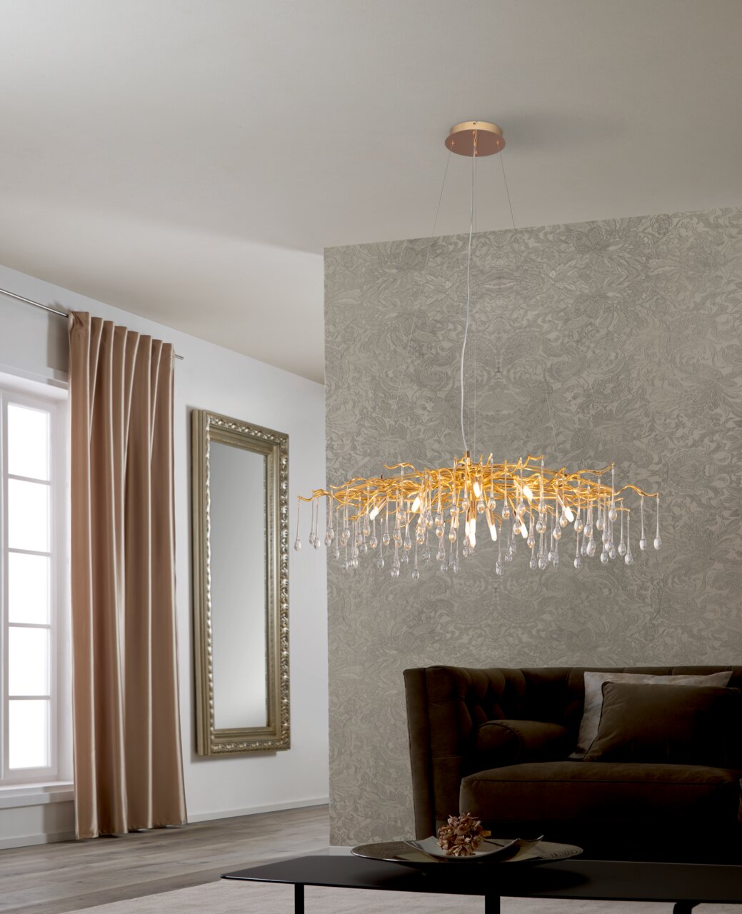 Moderne LED-Hängeleuchte mit goldenen Akzenten und Kristallanhängern, seitliche Perspektive im Wohnzimmer