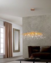 Moderne LED-Hängeleuchte mit goldenen Akzenten und Kristallanhängern, seitliche Perspektive im Wohnzimmer