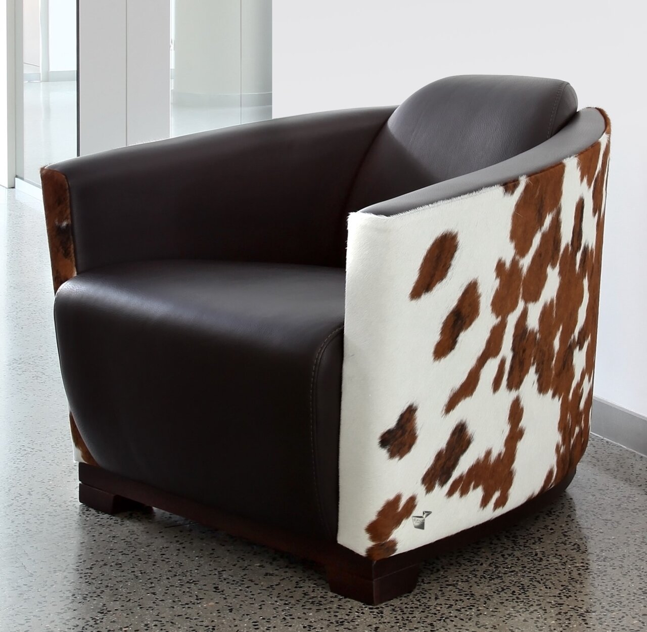 Moderner Sessel mit braunem Leder und Kuhfellmuster, seitliche Perspektive